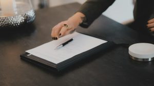 Asesor de MiempresaYA revisa documentación para cerrar una SL en Barcelona sobre mesa oscura con bolígrafo